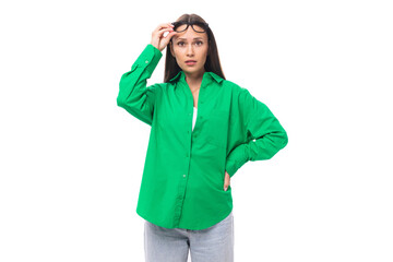 young european brown-eyed female model with well-groomed black hair and make-up dressed in a green shirt isolated on white background with copy space