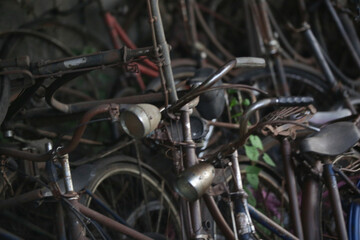 Fototapeta na wymiar Stack of vintage rusty bicycles in the workshop