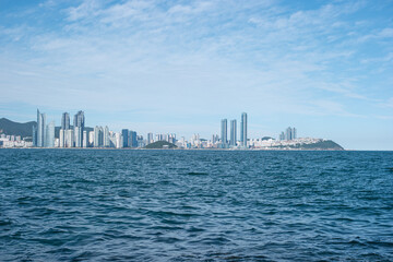 a row of buildings and skyscrapers lined up beyond the sea 