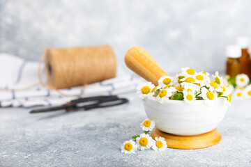 Chamomile flowers in mortar on a textured wooden table. Healing herbs. Alternative medicine. Healing. Homeopathy.Natural herbal organic cosmetics concept.Natural tea.Place for text. Copy space. 