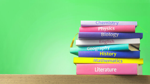 School colourfull textbooks on the table. Basic school subjects mathematics, literature, physic,s chemistry, copy space