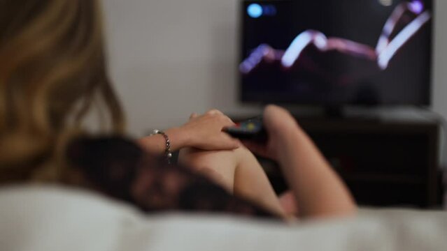 Woman watching erotic film at home.
