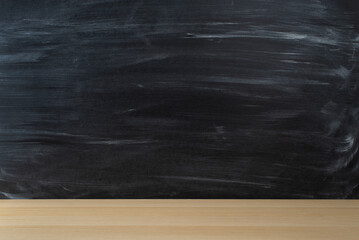 Back-to-school concept. Side view photo of wooden desktop against a chalkboard. Empty space for your content or advertising