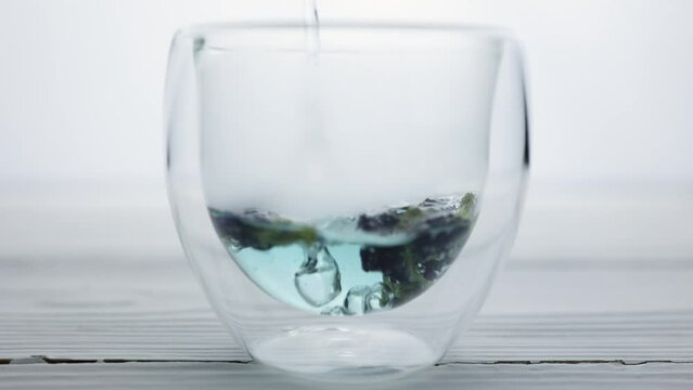 Pea tea "Blue butterfly" from the flowers of the clitoris close-up in a transparent glass. Recovery and detoxification of the body. Tea party
