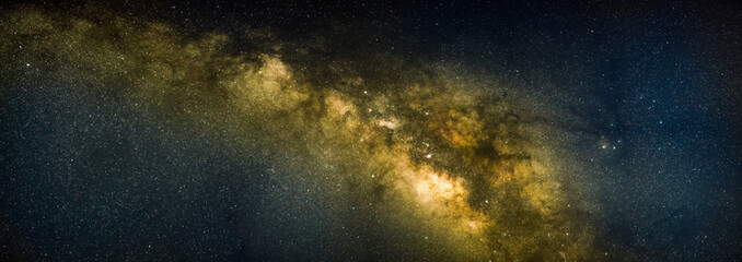 Panorama view of the Milky Way galaxy on a starry night sky with the core of the galaxy.