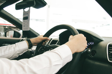 Close-up A businessman Hands put a watch Holding Steering Wheel with red console. Driving car concept. Safe driving concept.