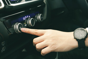 Hand of businessman open air conditioner volume the button of car. comfortable car or system in car concept.