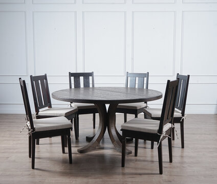 wood round table and chairs set on wood floor in white wall room