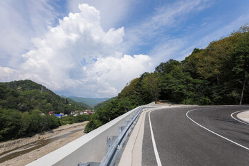 A new paved road in a picturesque mountainous area. Retaining wall and other elements of road construction. Russia, Sochi.