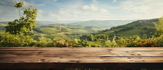 Wooden table sits against a green view of a vineyard