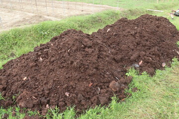 Heap of compost fertilizer on field