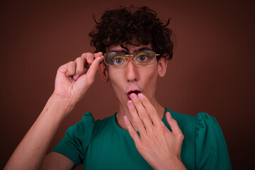 Funny drag queen posing in the studio on a brown background.