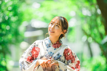 緑の中を歩く浴衣姿の日本人女性