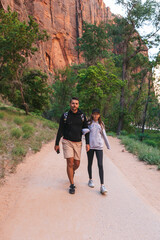 Father and his daughter hiking in the mountains. Family walking on pathway in Zion National Park, Utah, USA