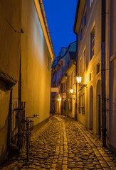 Narrow medieval street at night, old district in European town
