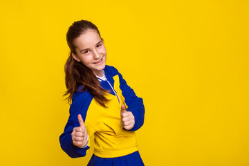 promotion and sale of sports goods, girl in sports clothes in Ukrainian flag colors on yellow...