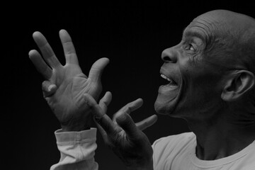 man praying to god with hands together worshiping God Caribbean man praying stock image stock photo	