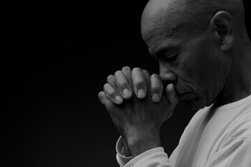 man praying to god with hands together worshiping God Caribbean man praying stock image stock photo	