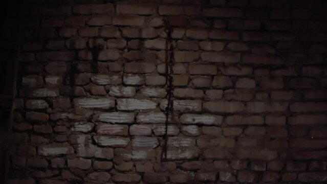 night, you can see an old red brick wall, on this wall hangs an old rusty iron chain and an old rusty iron hook, similar to a poker, handheld shooting
