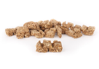 Dried fish pieces for dogs and cats as snack, treat or reward. Heap of dehydrated flaky fish chunks to break. Healthy dog snack or health supplement rich on protein, omega 3. Selective focus.