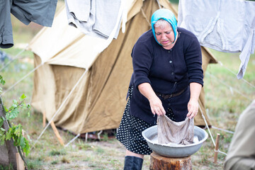Refugee camp. Refugee woman doing laundry outdoors.