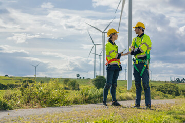 Engineer team man and woman field working together survey plan construction wind turbine clean...