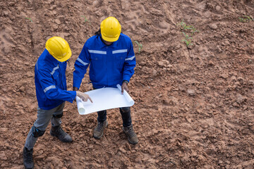 Land surveyor team standing working together at construction field consult study looking building...
