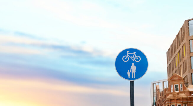 UK Road sign cycle and pedestrian pathway against a blue cloudy sky