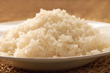 Plato de arroz blanco cocido en primer plano sobre una mesa de madera