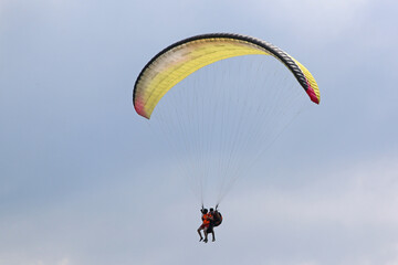 Tandem Paraglider flying in a blue sky	