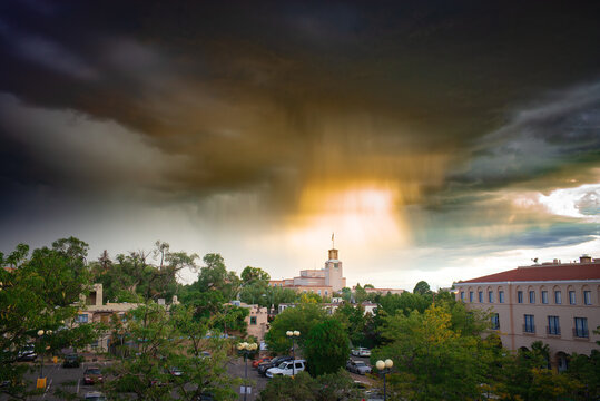The sun bursts through dark clouds over downtown Santa Fe, New Mexico after a storm