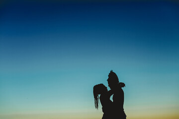 silueta de pareja enfrentada sobre cielo azul