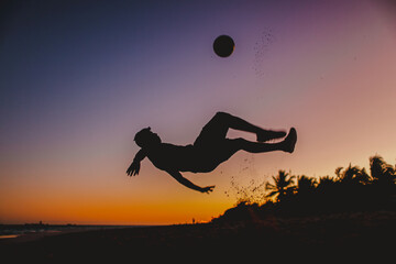 niño jugando a la pelota en un atardecer naranja