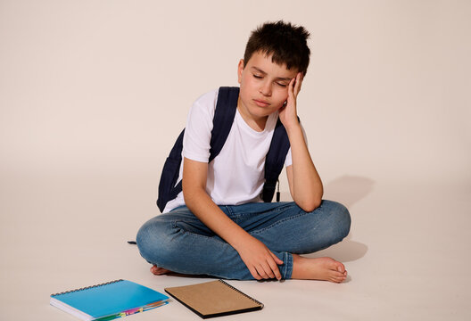 Upset teenager, school boy, holding head, demotivated , feeling difficulties with learning and problems at school
