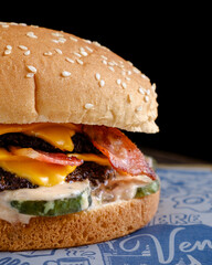 simple double cheese meat burger with many sauces and pickles on black background002