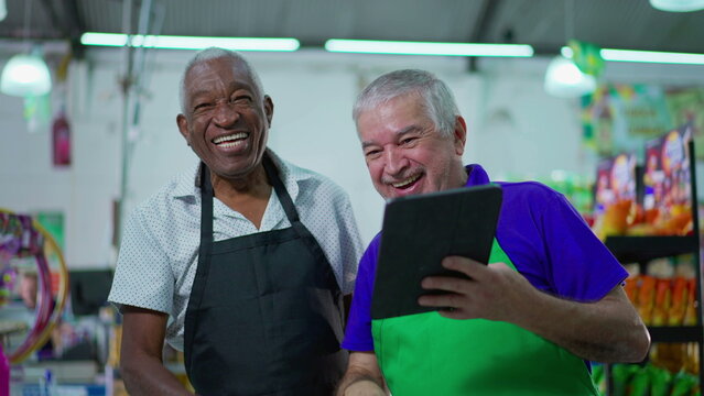 Candid Authentic Joy Between Older Supermarket Colleagues Doing High-five, Smiling Diverse Senior Men With Tablet Device, Workers Celebrating Success