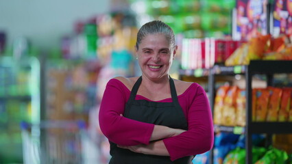 Joyful Female Grocery Store Worker Smiling at Camera with arms crossed, Wearing Apron