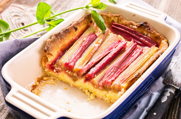Traditional German rhubarb pie with vegetable served as close-up on a design baking form