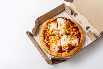 Pizza in a cardboard box on a white background. View from above. Pizza delivery. Copy space for text.