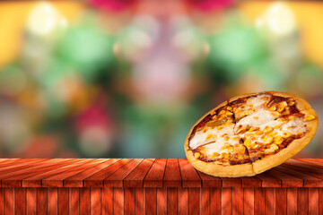 Pizza on wooden table over bokeh background with copy space