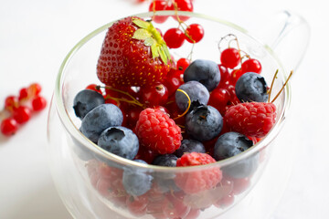 Strawberries, blueberries, currants in a cup