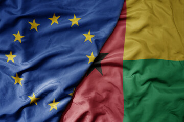 big waving realistic national colorful flag of european union and national flag of guinea bissau .