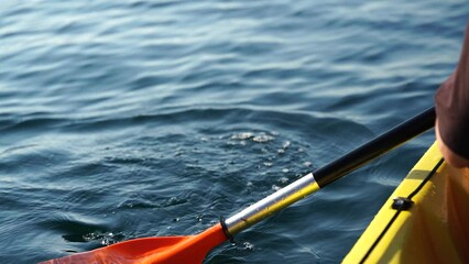 Kayak paddle sea vacation. Person paddles with orange paddle oar on kayak in sea. Leisure active lifestyle recreation activity rest tourism travel