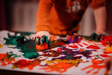 Cute little toddler boy painting with fingers at home. Creative games for kids. Stay at home...