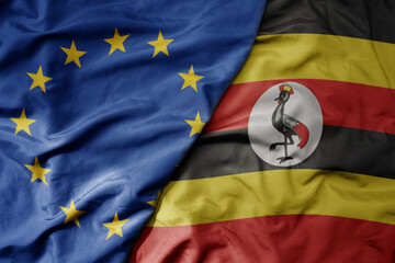 big waving realistic national colorful flag of european union and national flag of uganda .