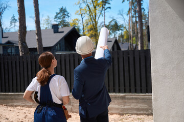 Back view male architect showing something to woman engineer