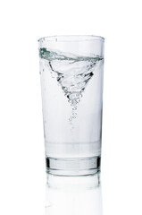 Water tornado in water glass close up isolated on white background