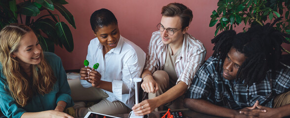International diverse group of students working on modern urban architecture project with renewable...