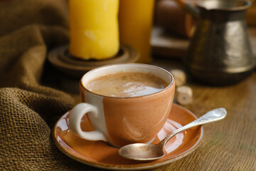 cup with drink coffee on old vintage wooden table, metal coffee maker, candles burn, caffeine improves functioning of human brain, stimulates nervous system, health benefits and harms, copy space