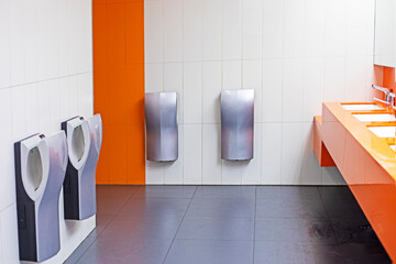 toilet with washbasins, hand dryers in a supermarket in light orange colors
